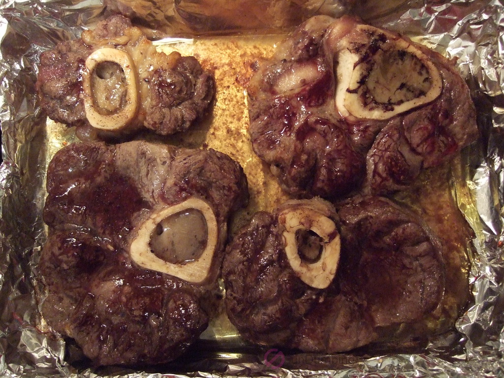 Roasted beef hindshank pieces in a baking pan