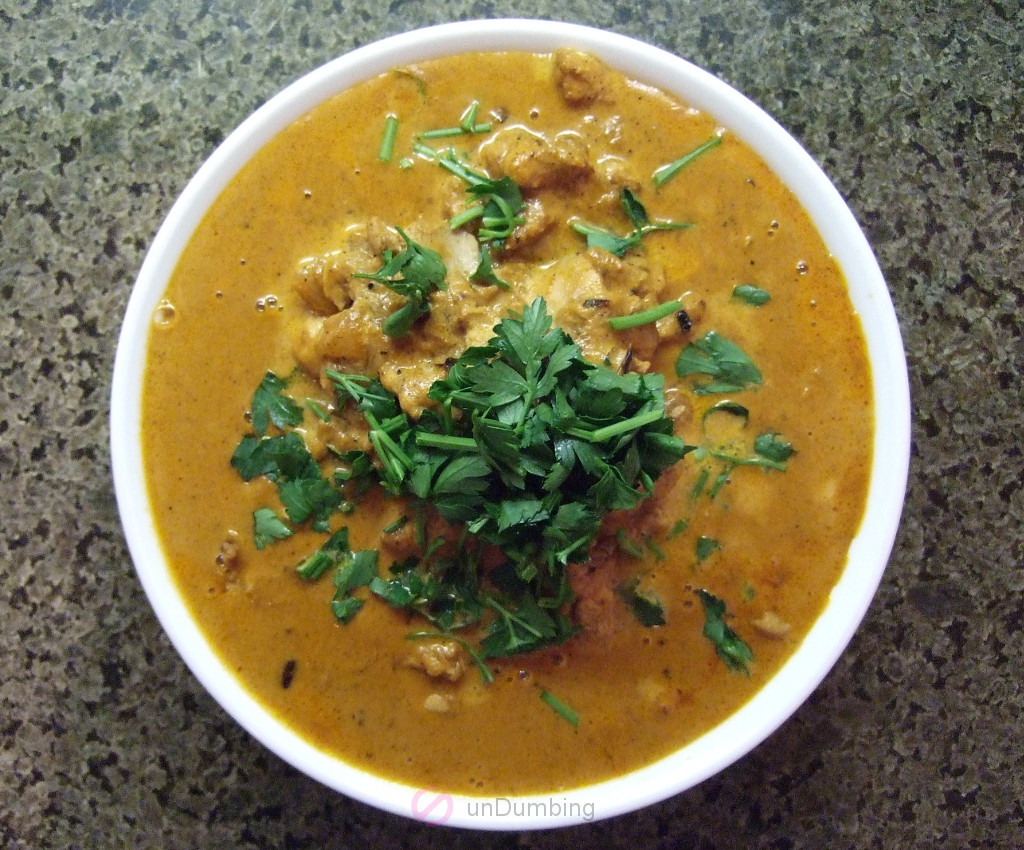 Butter chicken garnished with cilantro in a bowl