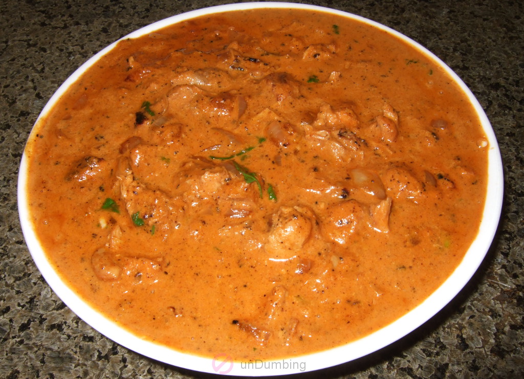 Bowl of butter chicken garnished with cilantro