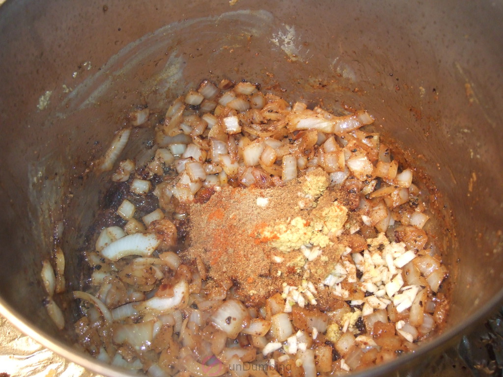 Garlic, ginger, and spices added to the pot of onions