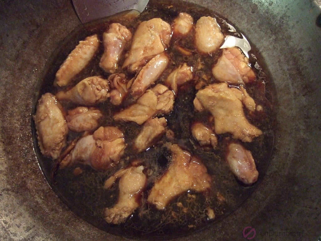 Soy sauce and rice wine added to the wok of chicken wings