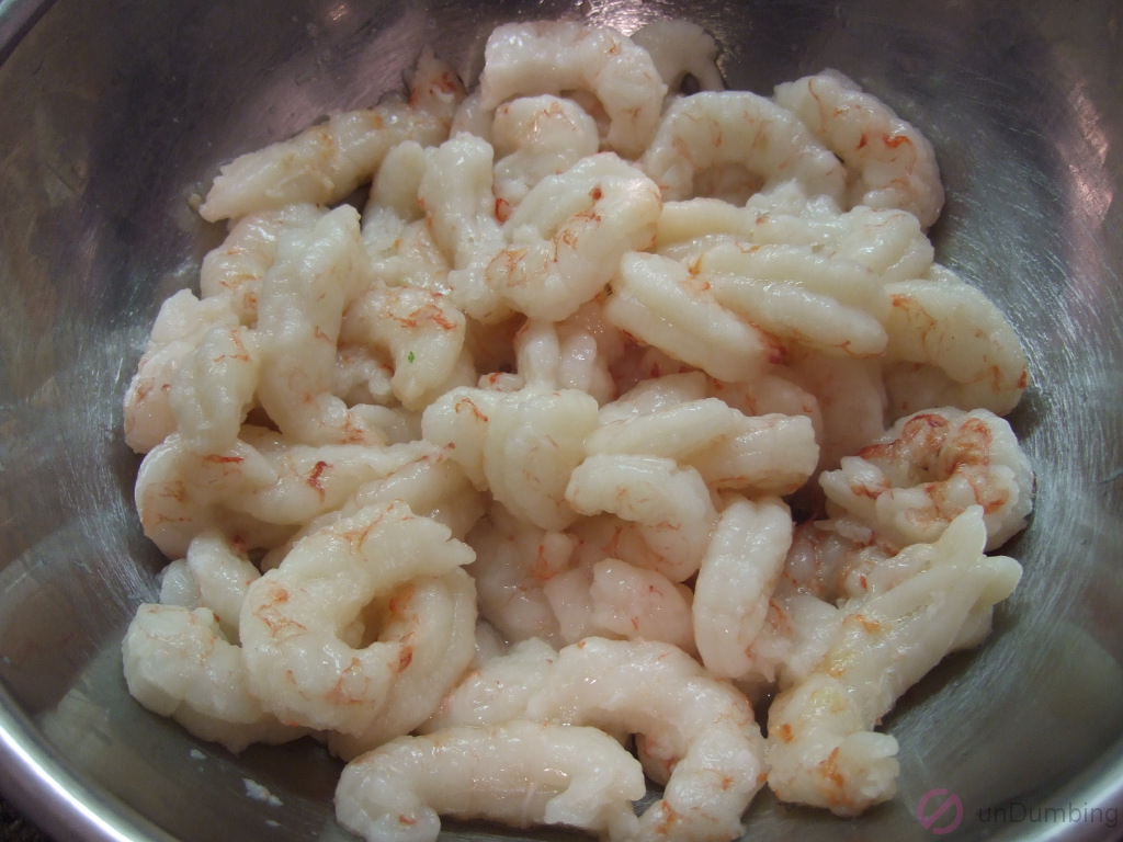 Shrimp marinating in a metal bowl