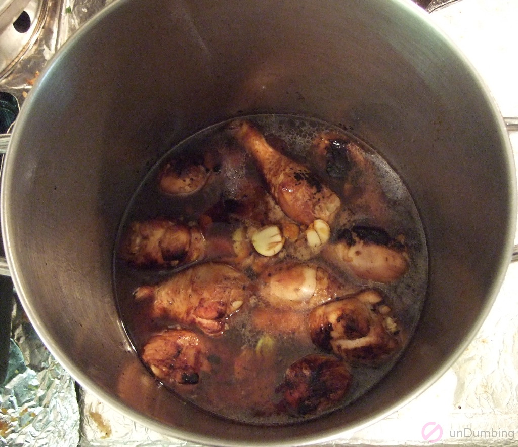 Bringing marinade and water to a boil in a pot with chicken