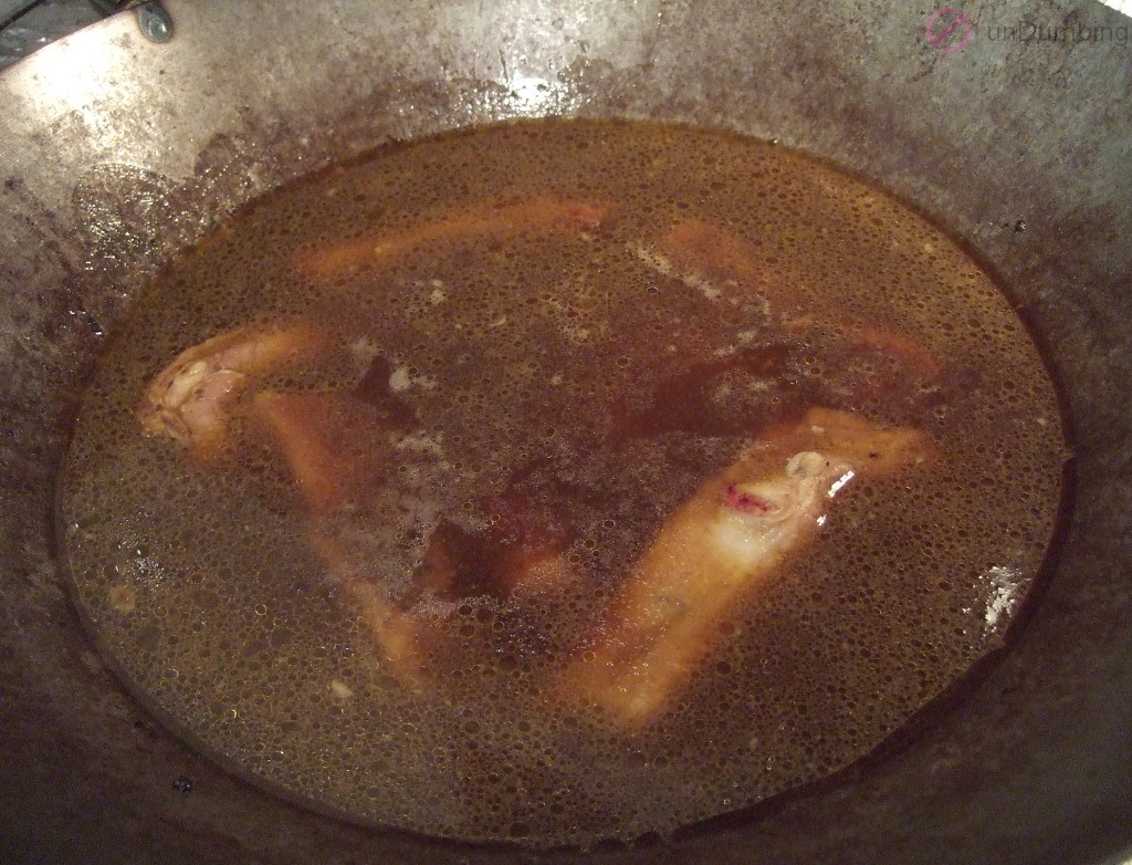 Ribs covered with water in a wok