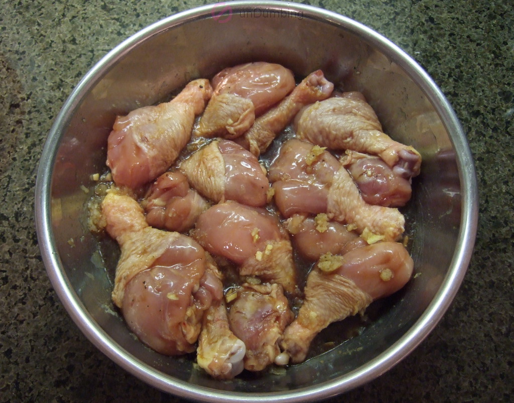 Bowl of chicken drumsticks marinating in the sauce mixture