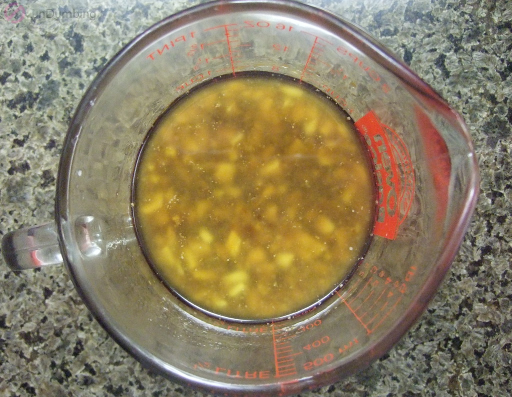 Mixture of melted butter, honey, soy sauce, garlic, salt, and pepper in a measuring cup