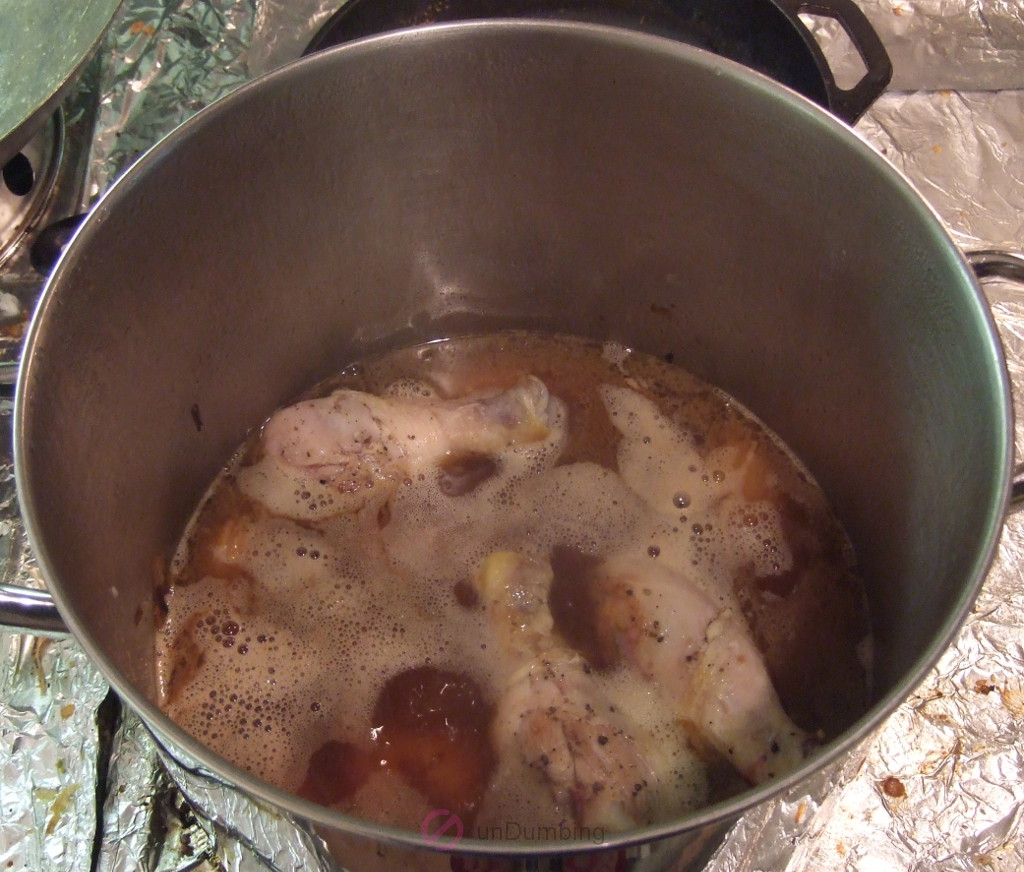 Pot of chicken simmering in chicken stock and water