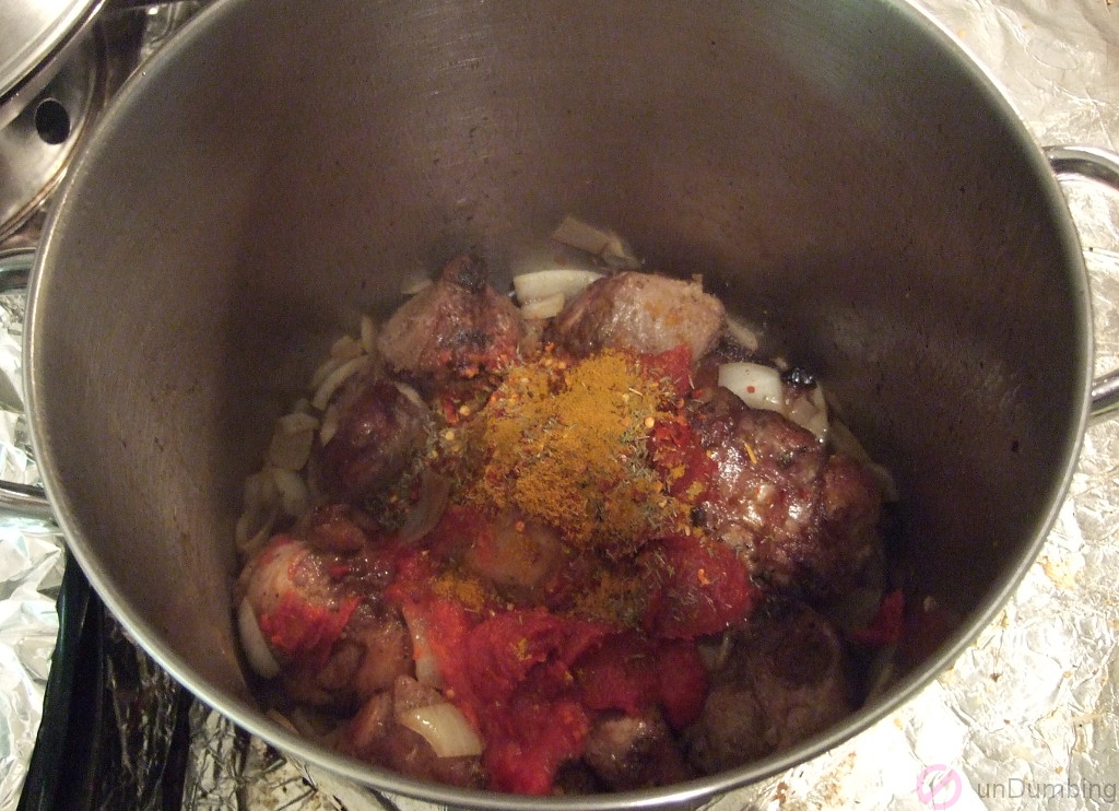 Tomatoes, tomato paste, thyme, curry powder and red pepper flakes added to the pot