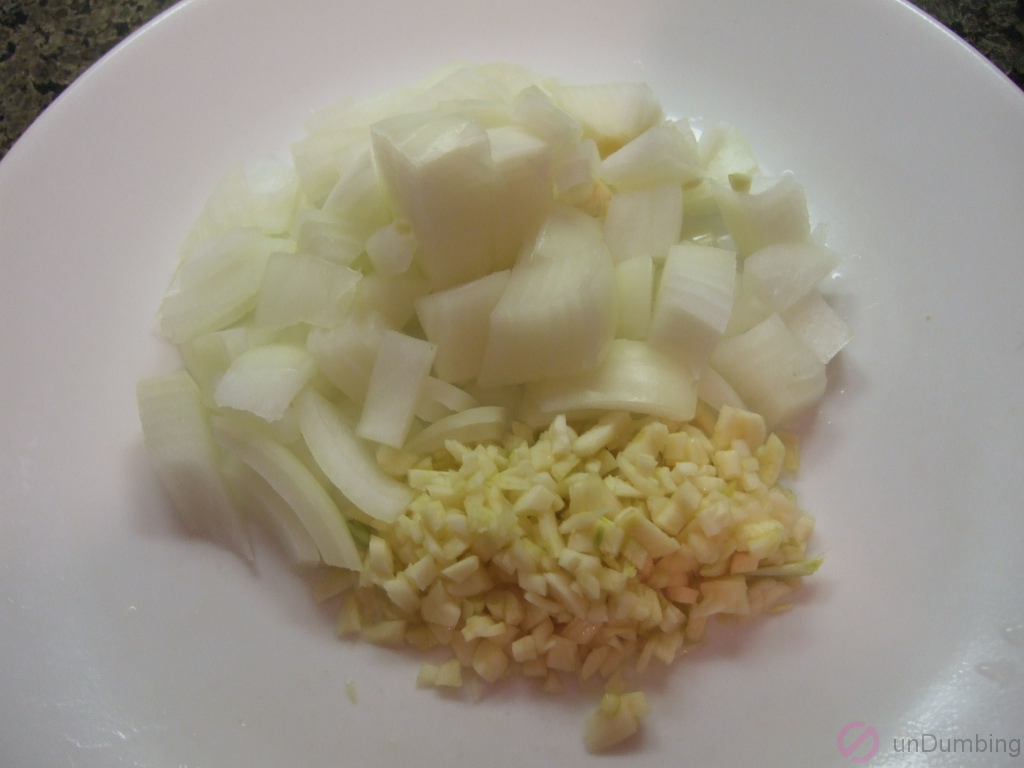 Chopped onion and minced garlic on a plate
