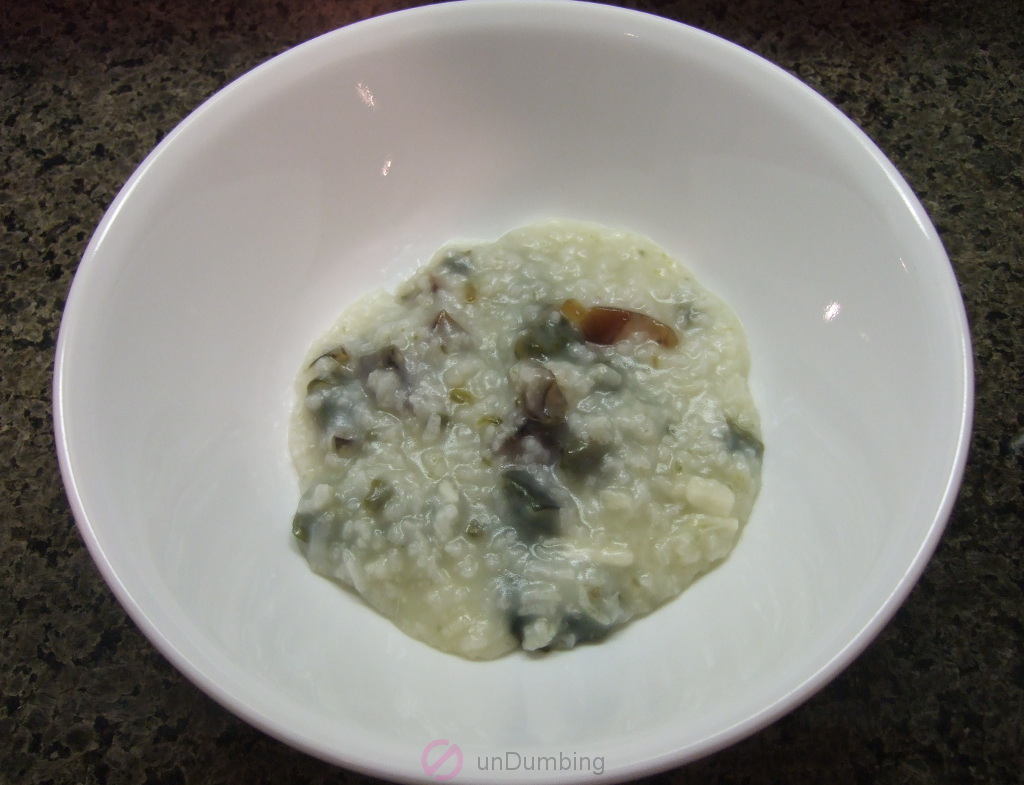 White bowl of porridge topped with thousand-year-old eggs