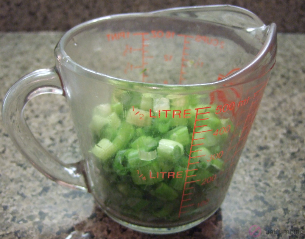 Chopped green onions in a measuring cup
