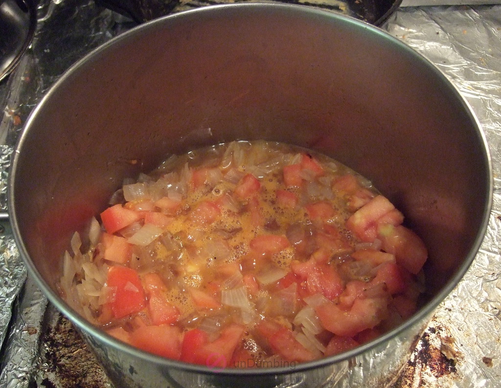 Tomatoes, water, salt, and pepper added to the saucepan