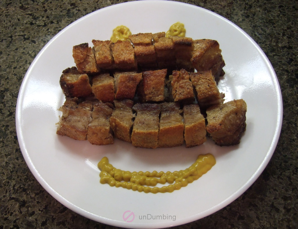 Bite-sized crispy pork belly with mustard on a white plate (Try 2)
