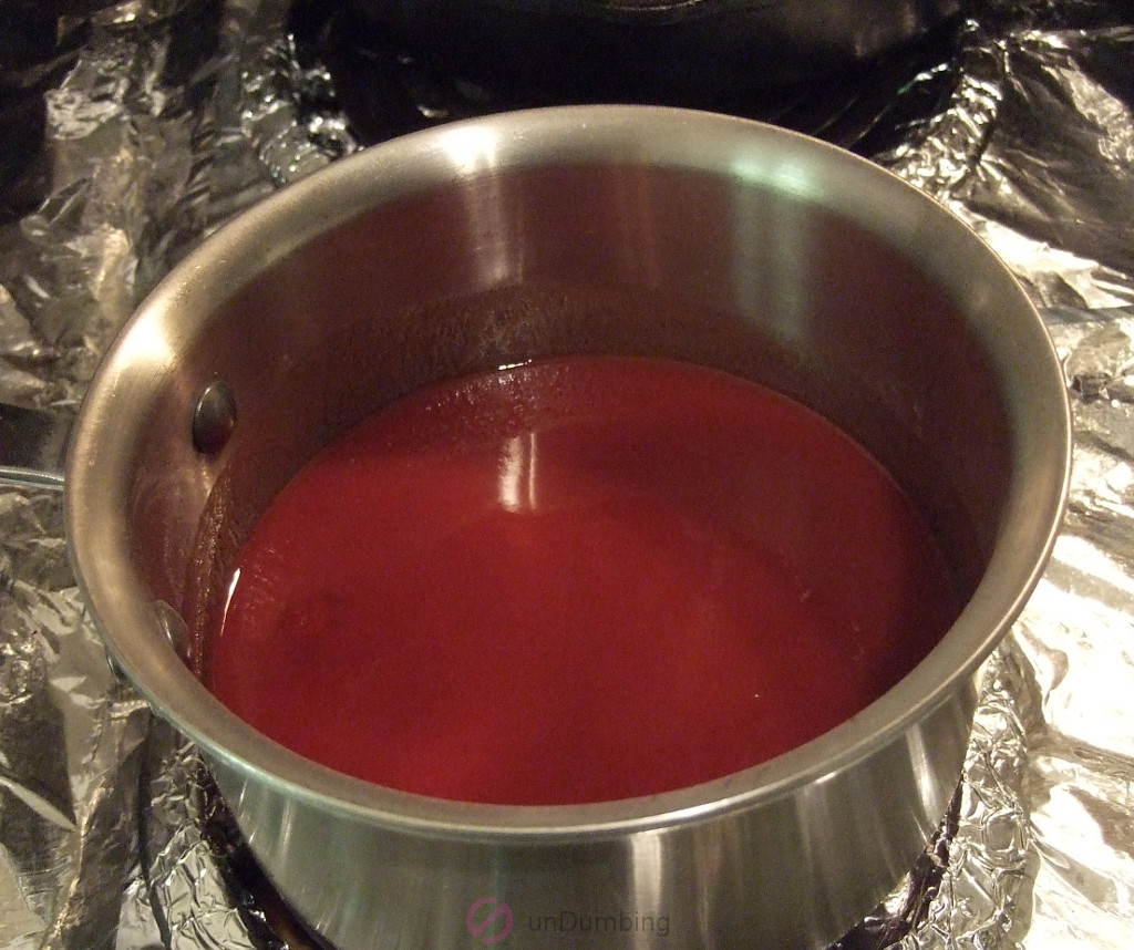 Bringing a saucepan of stirred-in ketchup, vinegar and water to a boil