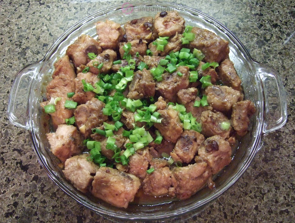 Steamed ribs garnished with green onions in a glass dish