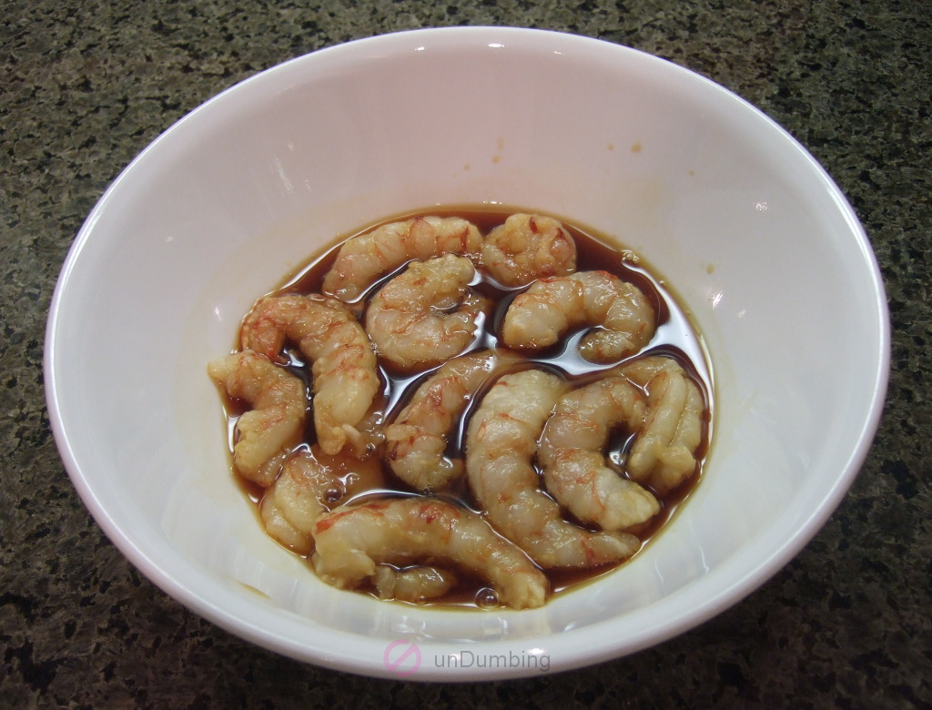 Shrimp marinating in a white bowl