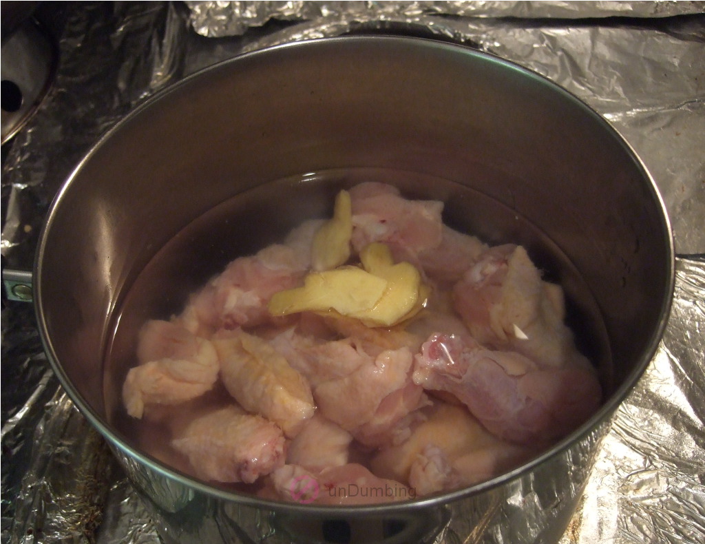 Chicken wings and ginger before boiling in a saucepan