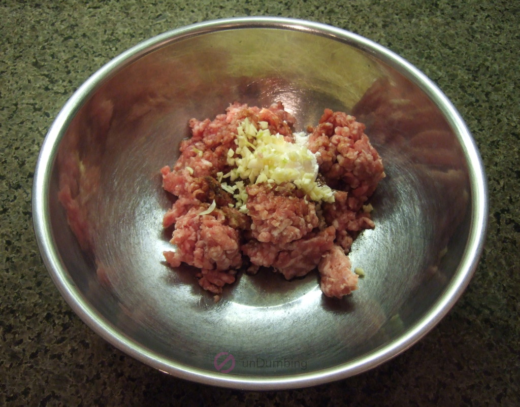 Meatball ingredients in a stainless steel bowl before mixing