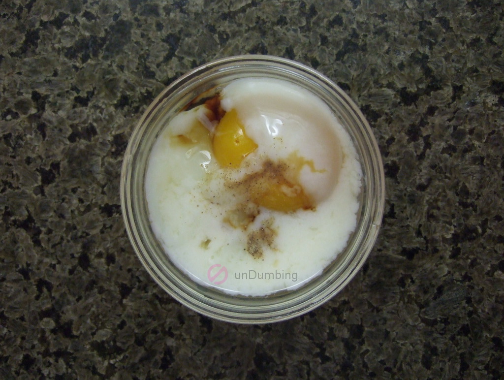 Poached egg in a glass ramekin with soy sauce and white pepper