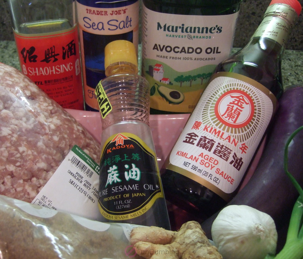 Chinese cooking wine, salt, oil, pork, sesame oil, soy sauce, eggplant, sugar, ginger, garlic. and green onion.