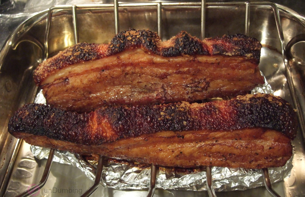 Crispy pork belly on a roasting rack over the plan