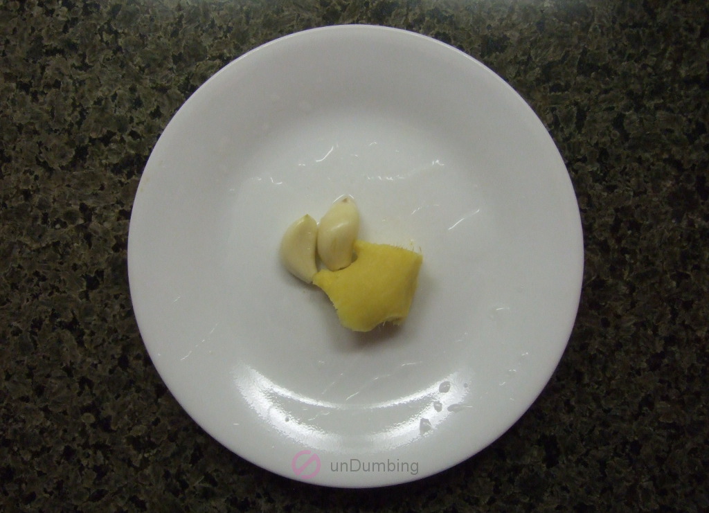 Ginger and garlic cloves on a white plate