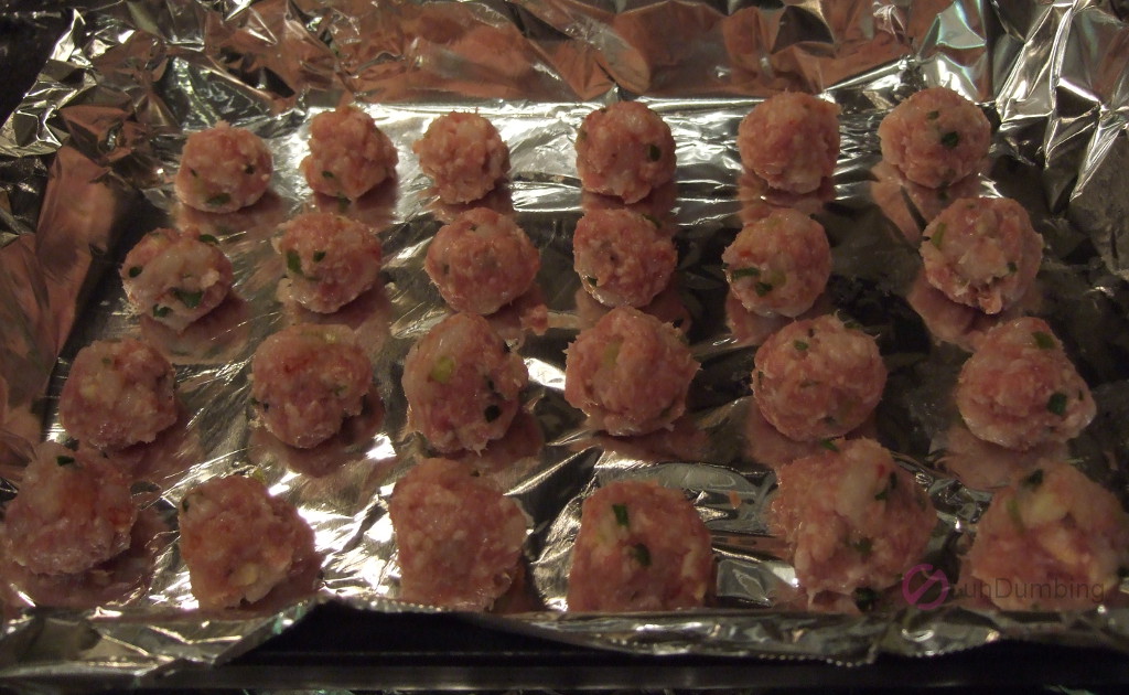 Shaped meatballs on a foil-lined baking pan