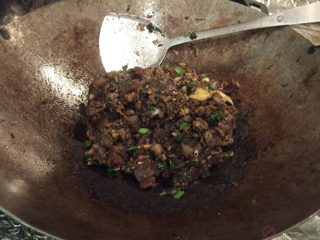 Soy sauce, sugar, and sesame oil mixed in with the rest of the ingredients in the wok