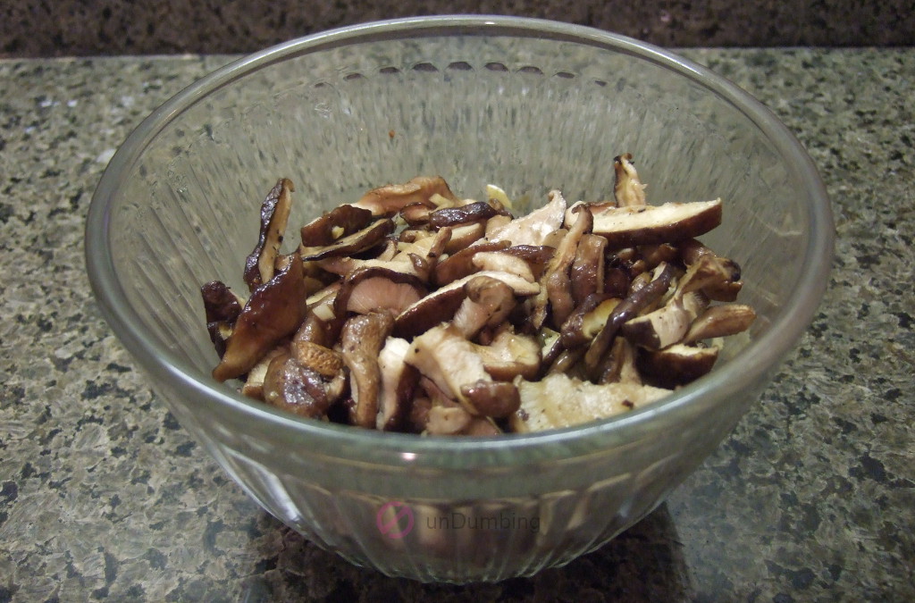 Clear bowl of garlicky roasted shiitake mushrooms