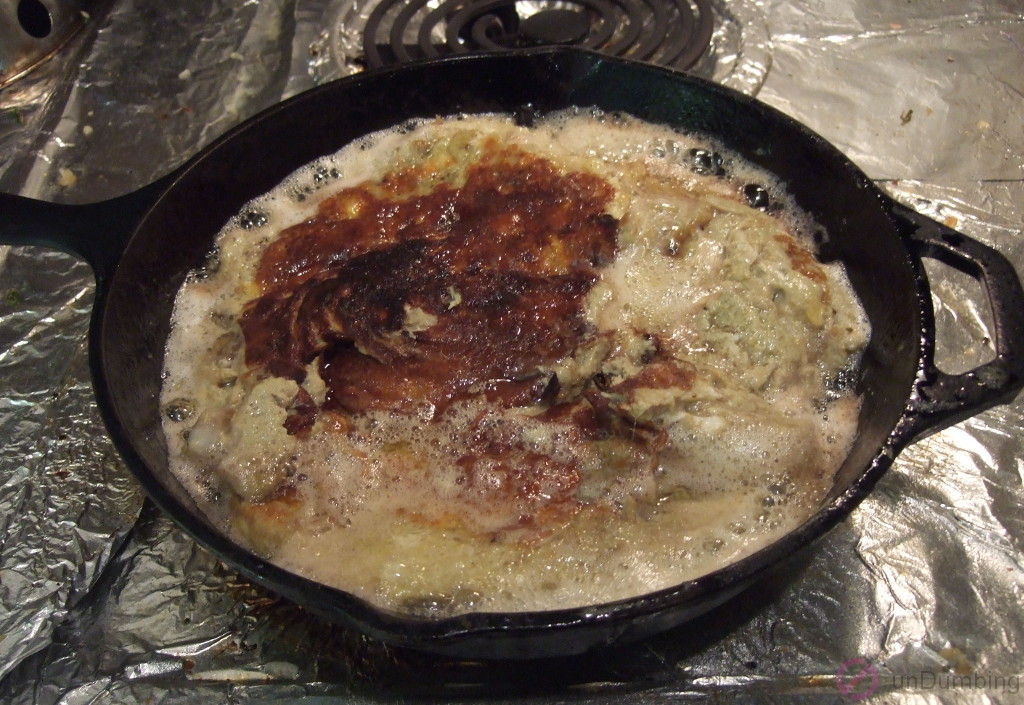 Flipped egg and eggplant mixture cooking in a skillet