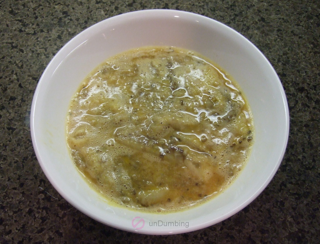 Beaten eggs and mashed eggplant in a white bowl