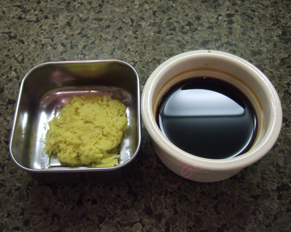 Stainless container of grated ginger and off-white ramekin with seasoning