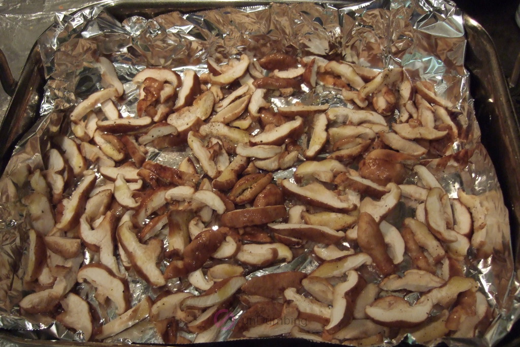 Seasoned mushrooms on a foil-lined roasting pan