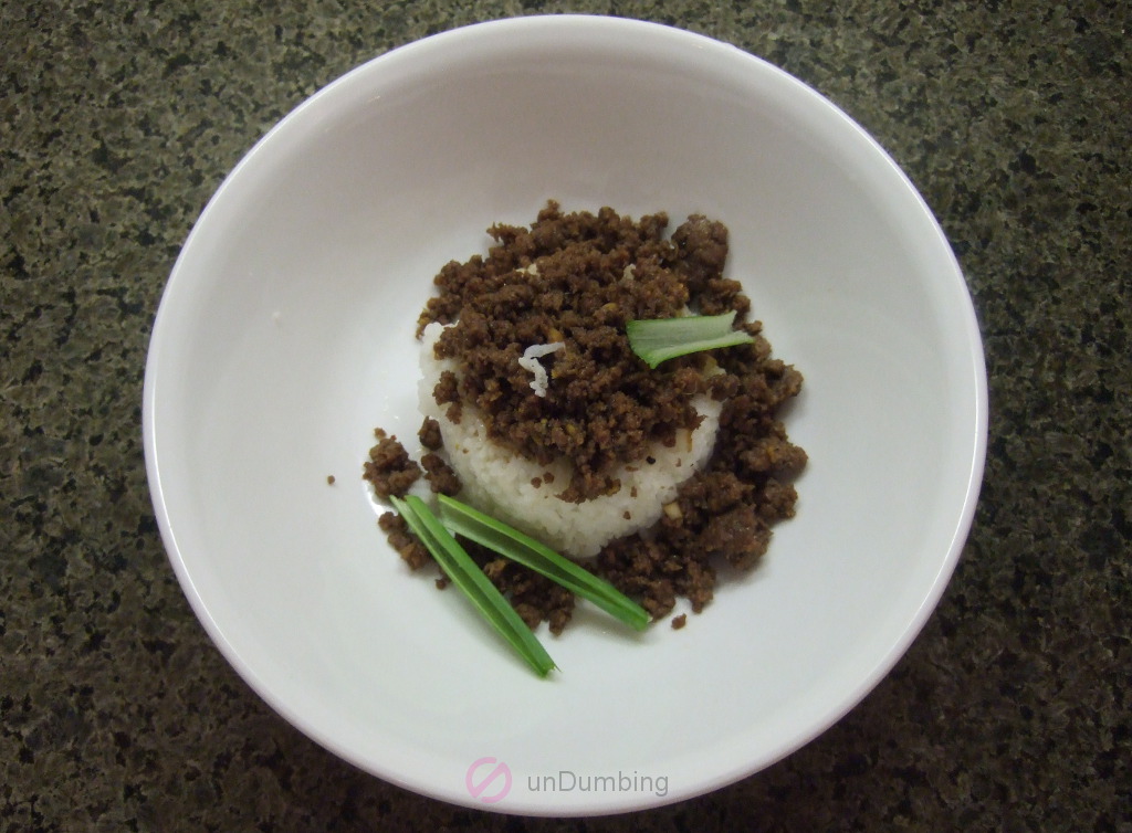 Ground beef, green onion slices, and white rice in a white bowl