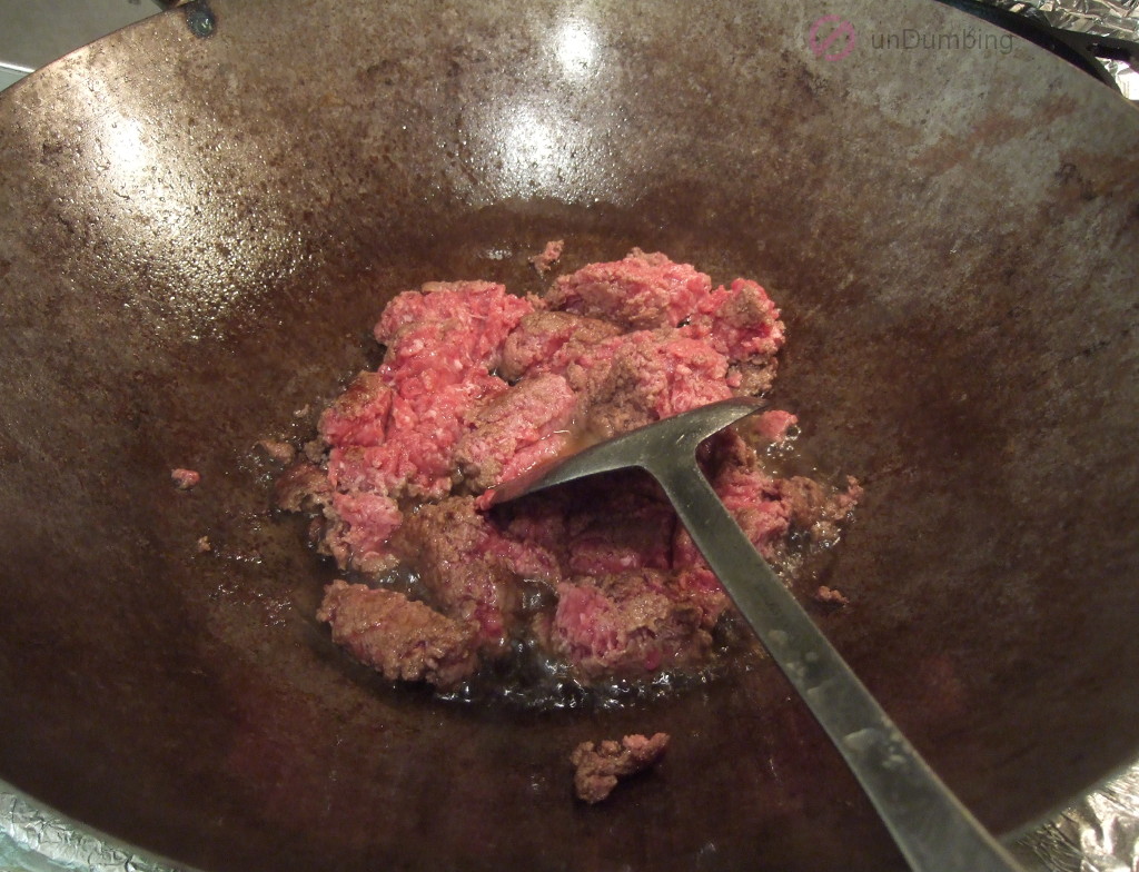Ground beef added to the wok