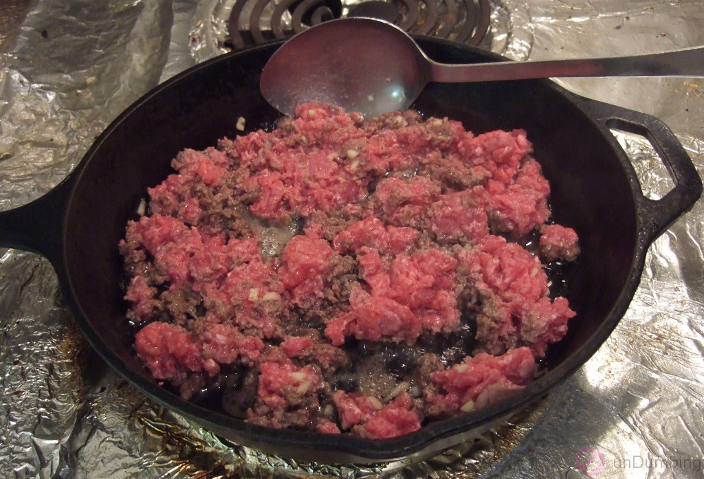 Ground beef and garlic cooking in a skillet