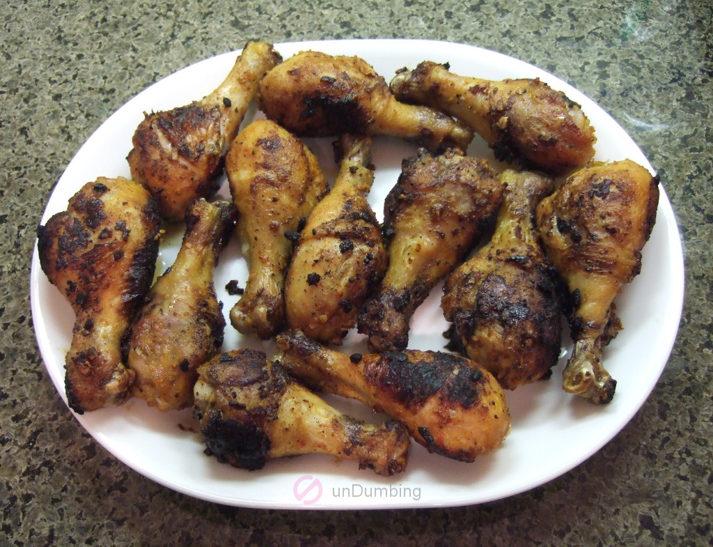 Baked chicken drumsticks on a white plate