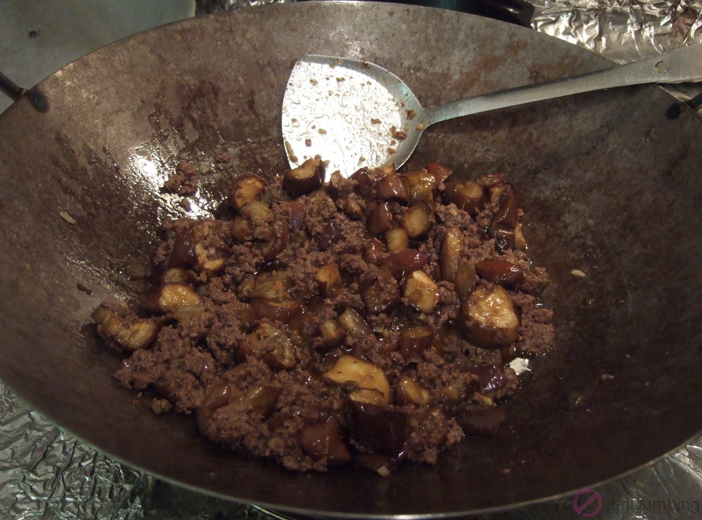 Beef, eggplants, and sauce cooking in a wok
