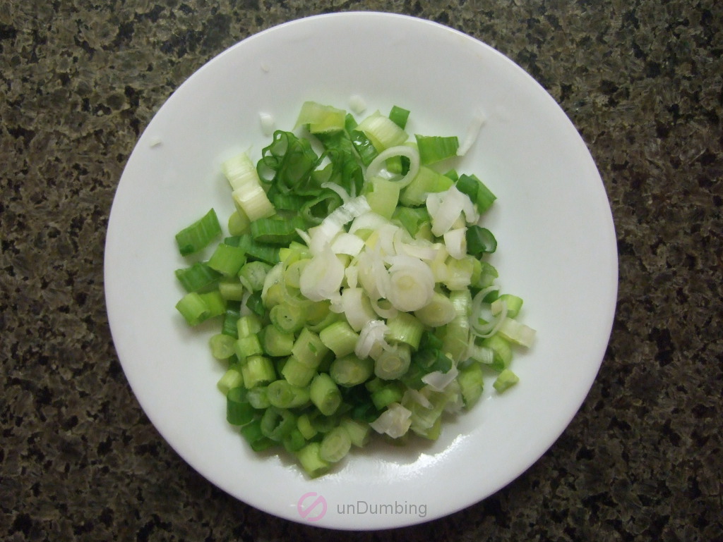 Chopped green onions on a white round plate