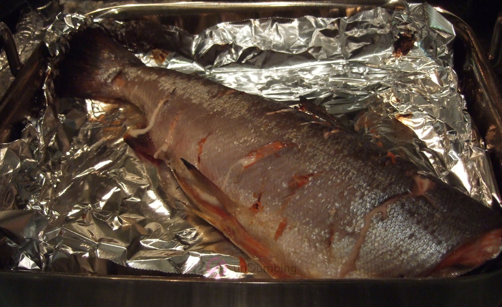 Cooked salmon resting on a foil-lined roasting pan