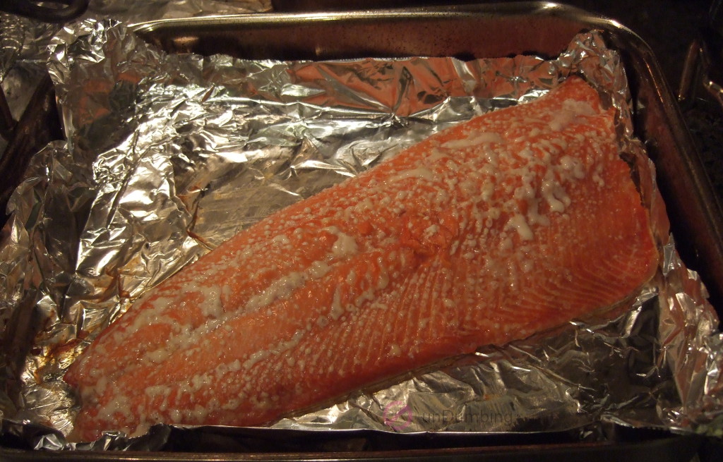 Cooked salmon resting on a foil-lined roasting pan (Try 2)
