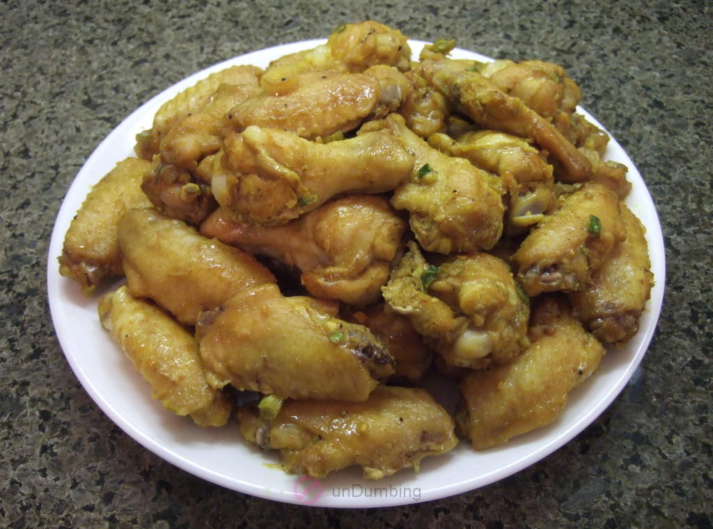 Curry-spiced chicken wings on a white plate (Try 2)
