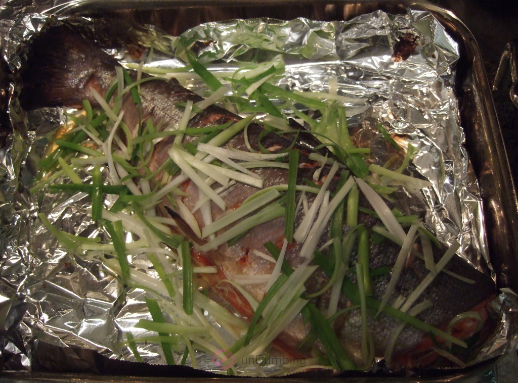 Garnished salmon on a foil-lined roasting pan