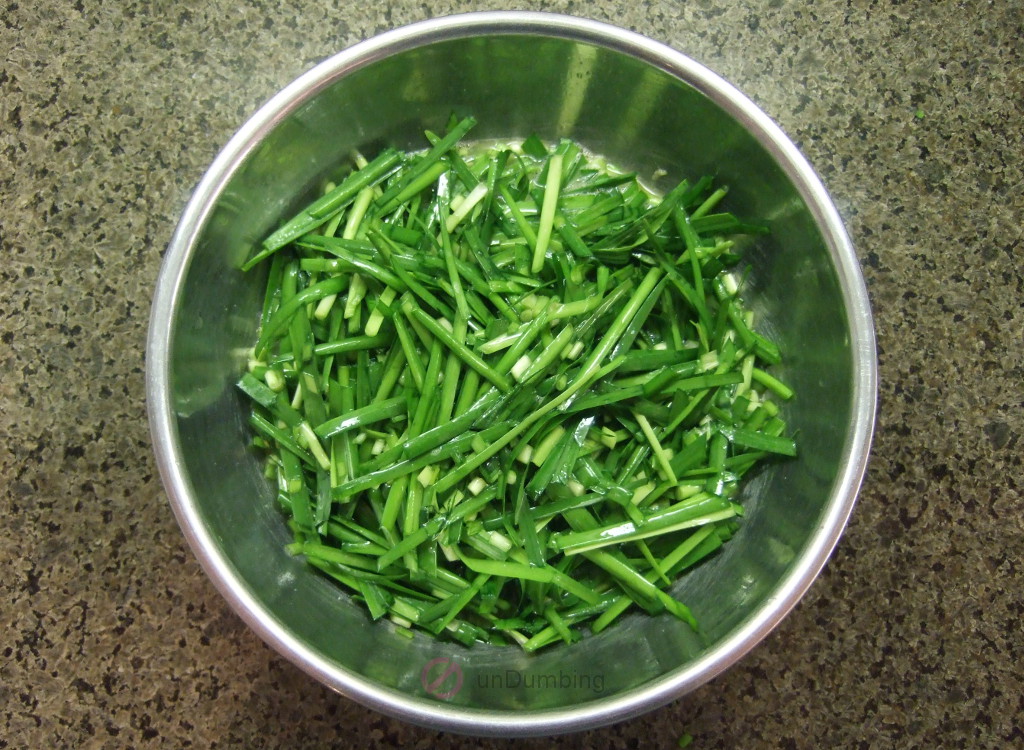 Chinese chives combined with beaten eggs in a stainless steel bowl