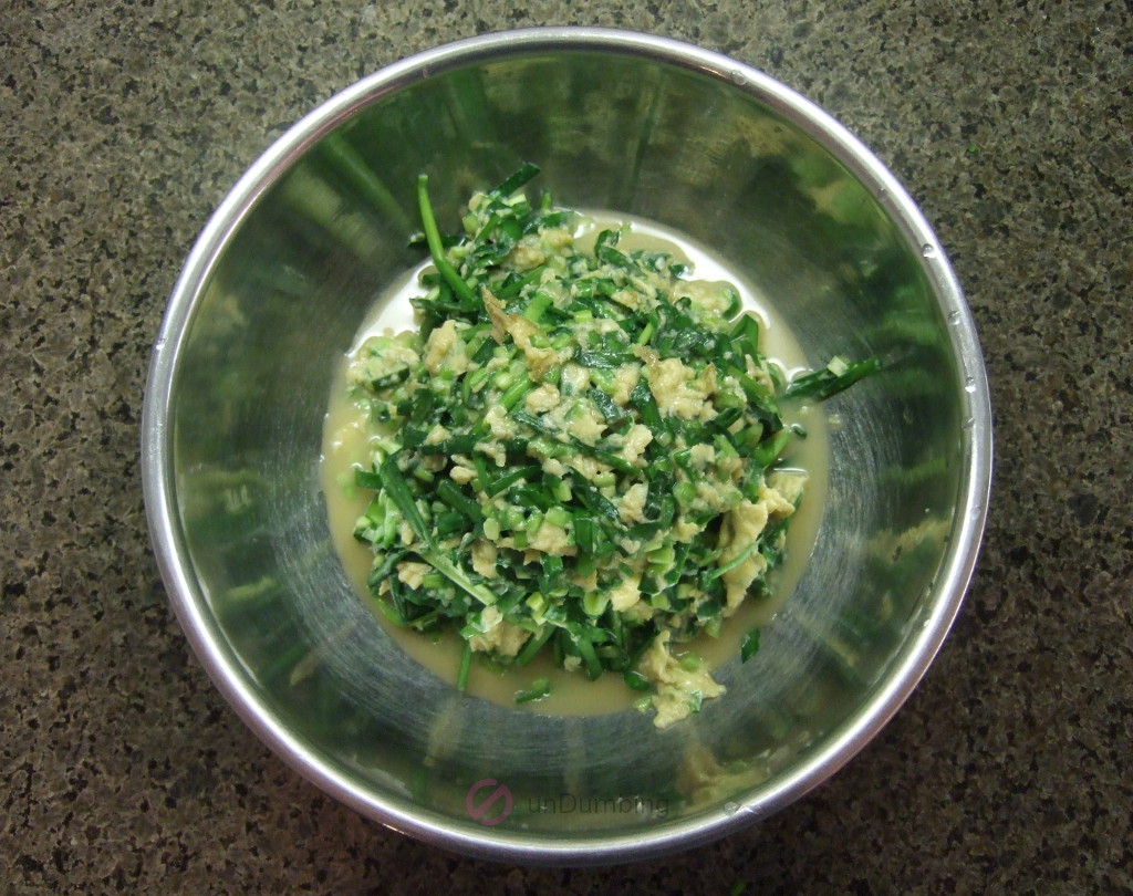 Cooked Chinese chives and eggs in a stainless steel bowl