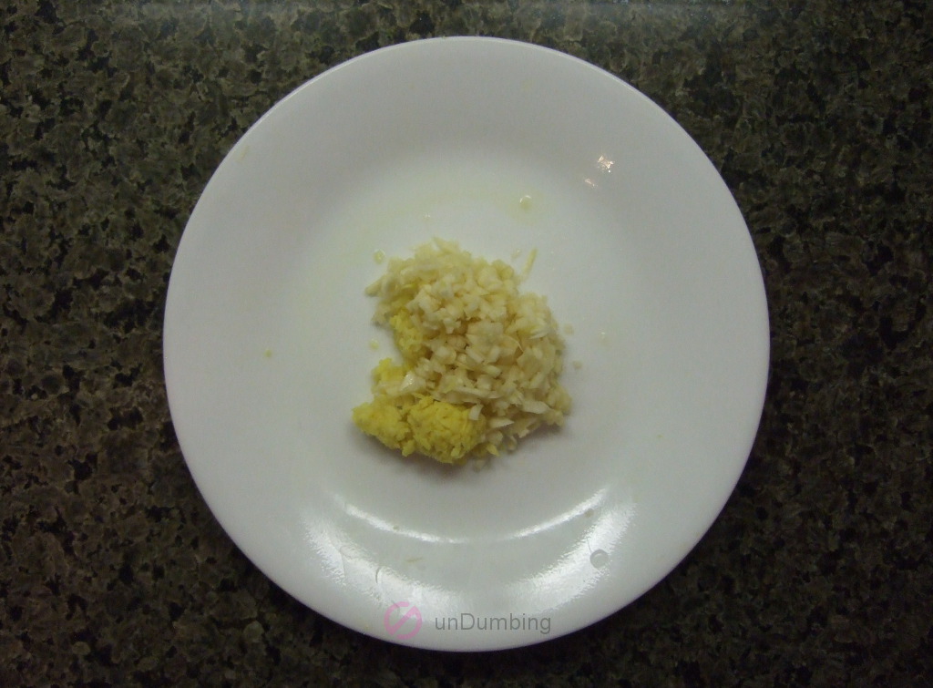Chopped garlic and grated ginger on a white plate