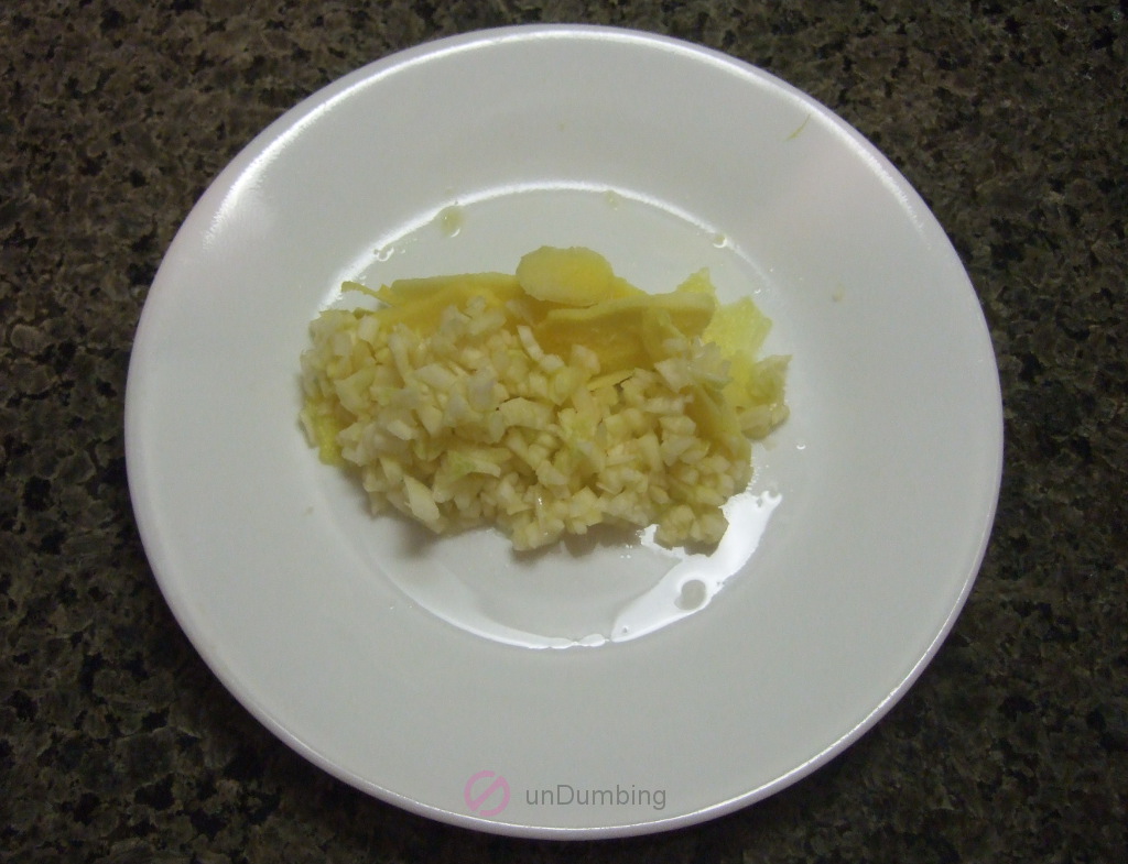 Minced garlic and sliced ginger on a white plate