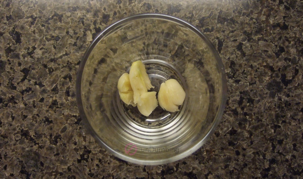 Crushed garlic cloves in a shot glass