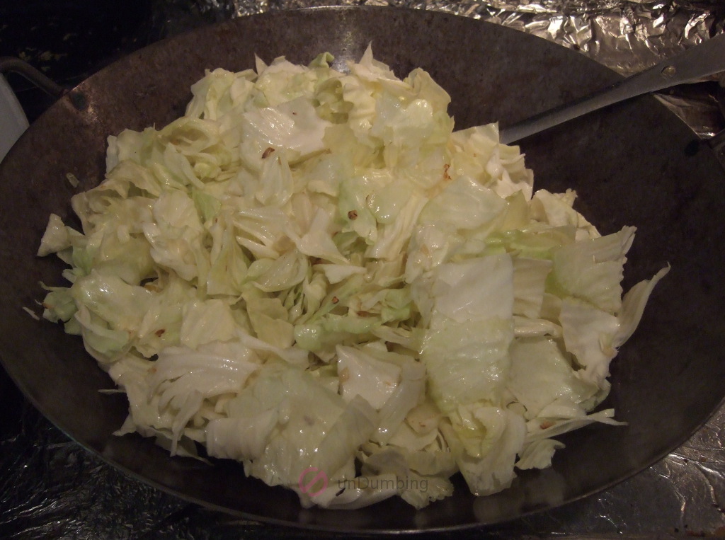 Partially stir-fried cabbage in a wok