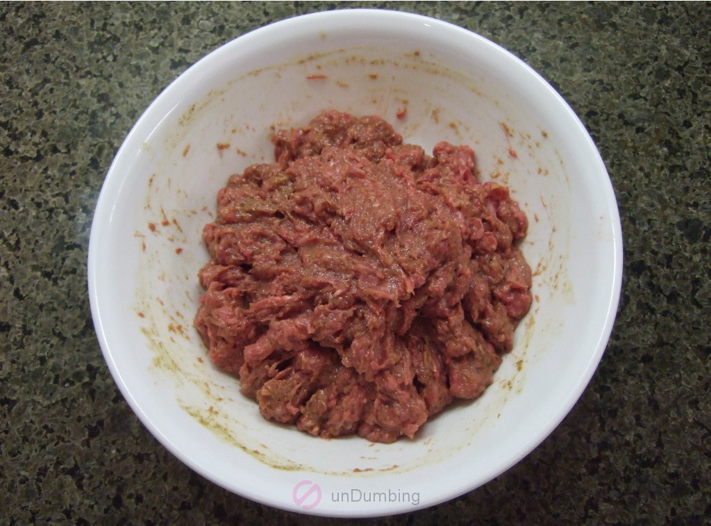 Beef marinating in a white bowl